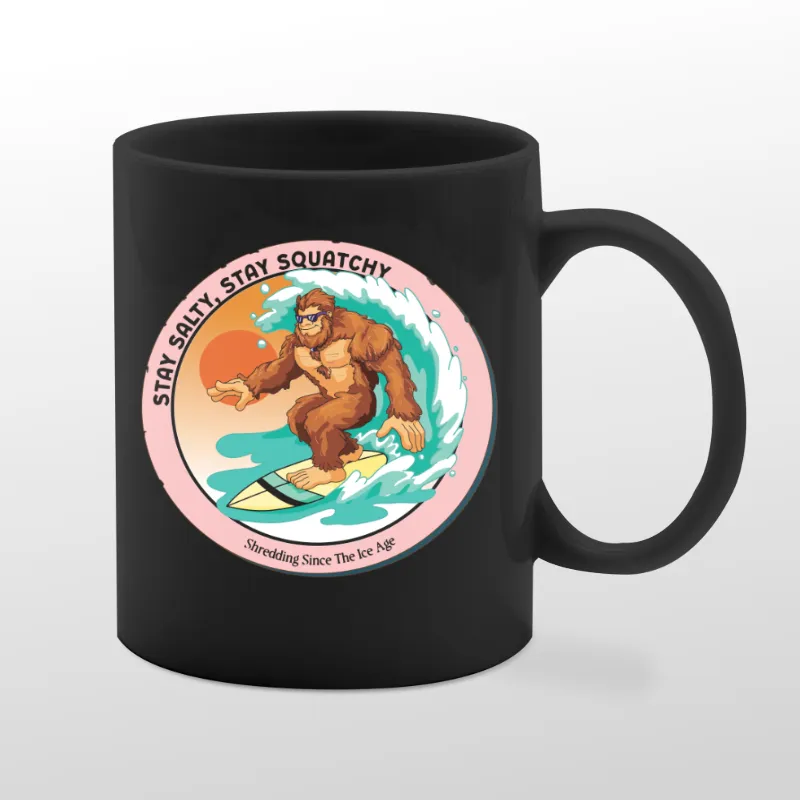 Black mug with Bigfoot surfing graphic